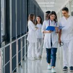 equipe-de-jovens-medicos-especialistas-em-pe-no-corredor-do-hospital